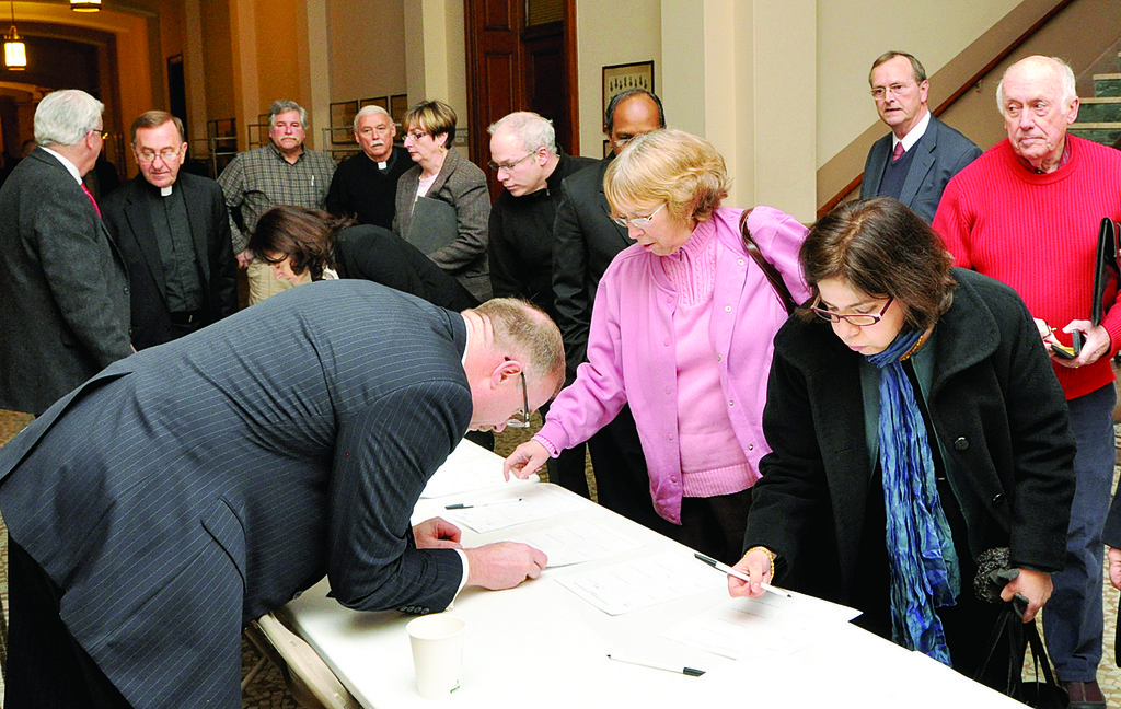 SIGNING IN—Parish committee members put their names on the record before “Making All Things New” planning meeting at St. Joseph’s Seminary Jan. 20. Priests and pastors also participated.