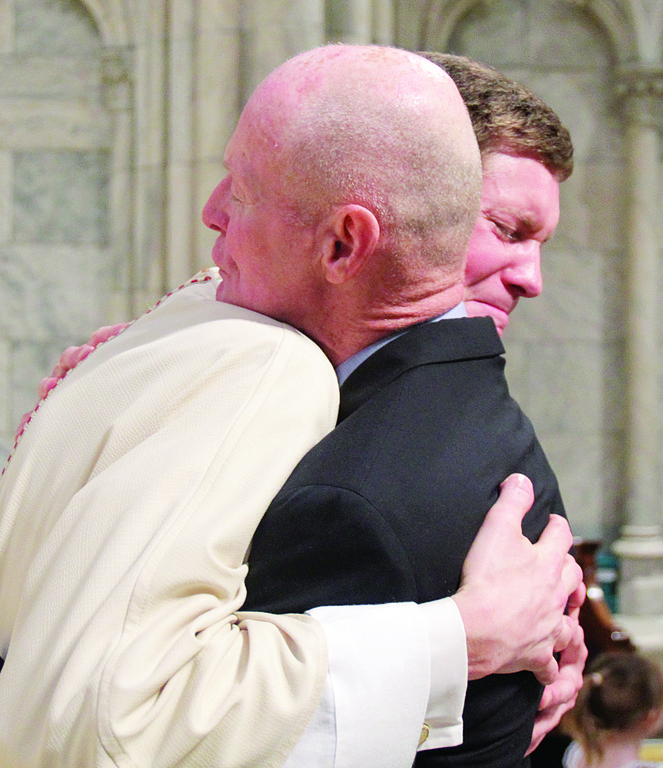 HEART OF THE FAMILY—Silence says more than words could as Father Brian Graebe embraces his father, Henry, after giving him a blessing.