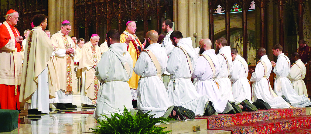 FROM APOSTOLIC TIMES—Archbishop Dolan reads prayer during rite of ordination. Sacrament of holy orders extends back in time to the Apostles, who conferred priesthood through prayer and the laying on of hands, as bishops have done ever since.