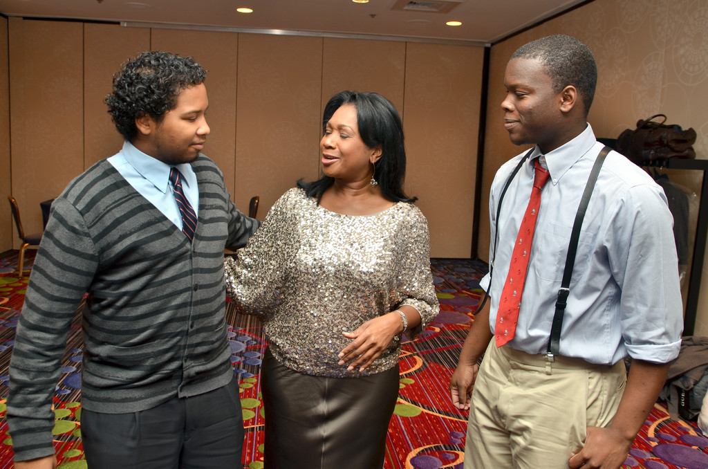 HONOREES—Newscaster Sandra Bookman, the master of ceremonies at the dinner, chats with Pierre Toussaint scholars Gabriel Rangasammy and Justin Lokossou.