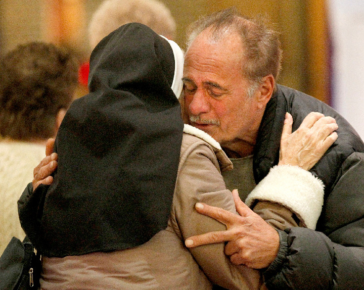 CONSOLATION—Dominican Sister Jeanine Conlon comforts John Mennella after a Nov. 7 Mass dedicated to people affected by Hurricane Sandy at St. Charles Church on Staten Island. Mennella said he lost everything in his home during the monster storm that claimed the lives of three members of the parish.