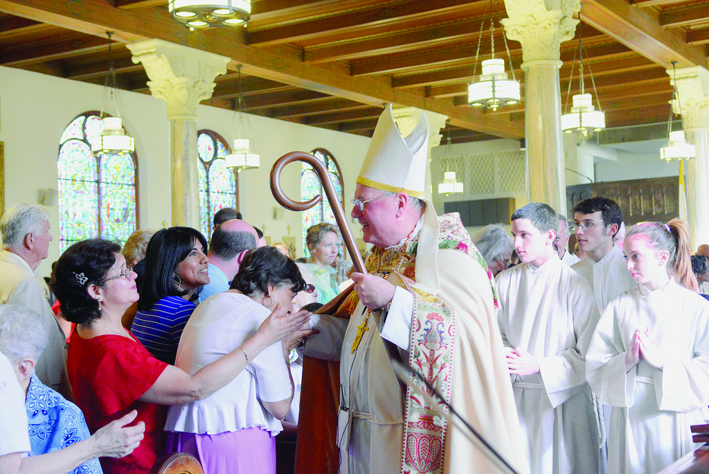 SOLID FAITH—Cardinal Dolan greets parishioners of Holy Family Church in New Rochelle during the parish Centennial Mass he celebrated June 1.
