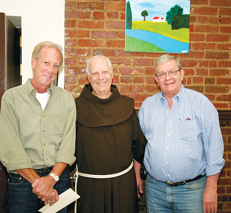 MEN OF VISION-Father John Felice, O.F.M., center, flanked by Father Thomas Walters, O.F.M., left, and Father John McVean, O.F.M., right, at St. Francis Residence II on West 22nd Street in Manhattan, one of three residences the friars operate for mentally ill people. Behind them is a painting by one of the residents.