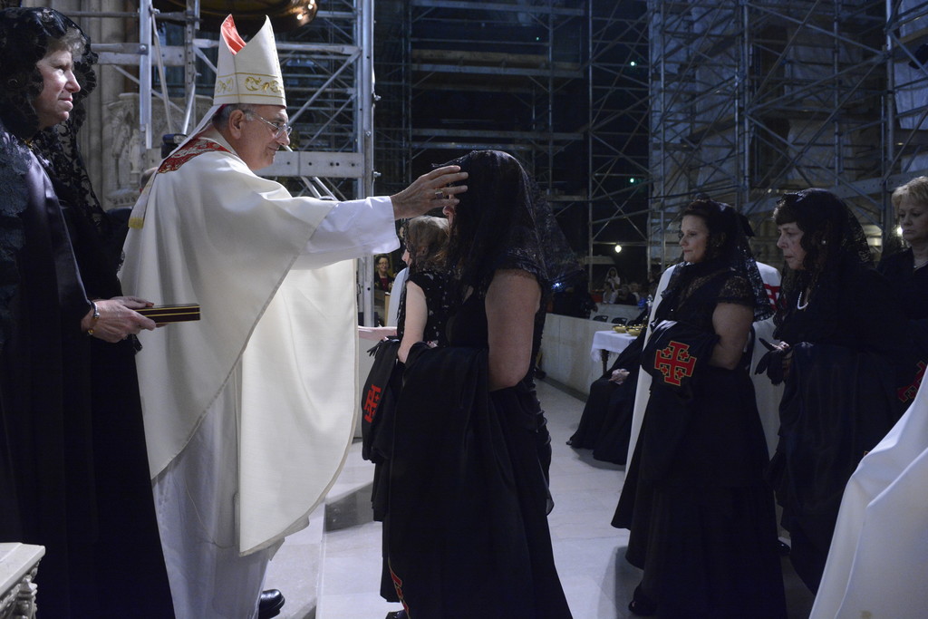 Bishop Nicholas DiMarzio of Brooklyn makes sign of the cross on the forehead of each lady during the ceremony.
