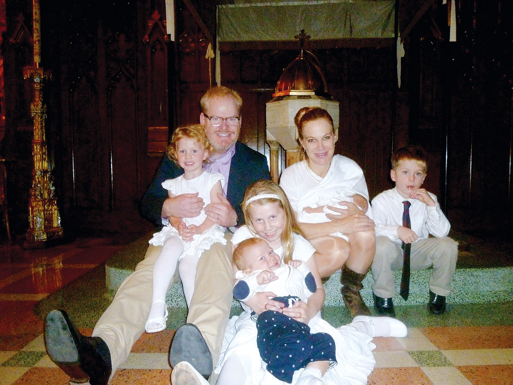 BLESSED—The Gaffigan family, in 2012 at the baptism of youngest child, Patrick, at their parish, the Basilica of St. Patrick’s Old Cathedral in lower Manhattan: Jim, holding Katie; Jeannie holding Patrick; Jack, and in front row, Marre holding Michael.