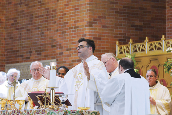 Father Eguino prays during the June 27 liturgy, offered at his home parish church of St. Benedict’s in the Bronx. Some 50 Salesian, diocesan and other religious priests were concelebrants.