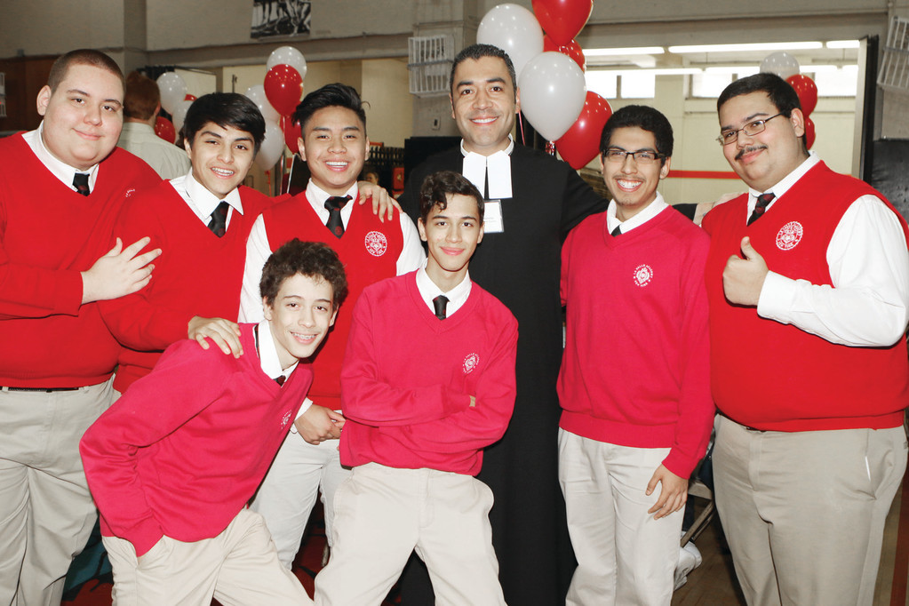 Top row from left, La Salle Academy seniors Matthew Perez, Derek Criollo, Jeremiah Katigbank, Christopher Cumbe and Jeremy Ferrer and, bottom row, twins Jancalo and Joshua Mediavilla, strike a joyful pose with Brother Anwar Martinez, F.S.C., a teacher at the boys’ high school in Manhattan, where enrollment is on the rise.