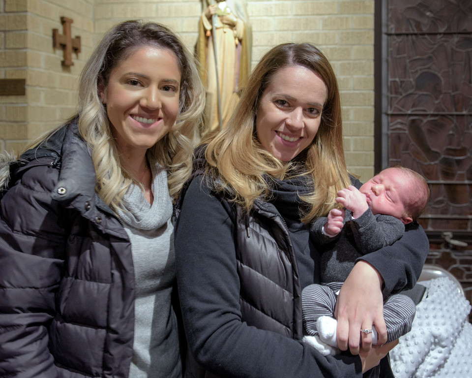Pina Rinaldi, holding her 3-week-old baby, Alessio, received Communion and a blessing for her baby from the cardinal. Pina’s sister, Maria, attended the Mass with them.