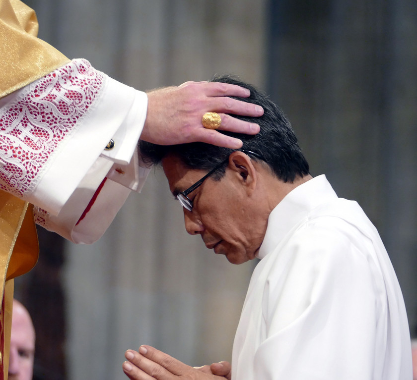 ORDINATION RITE—The laying on of hands is an important component of the ordination rite. Cardinal Dolan lays his hands on Deacon Raymundo Masbad, one of 12 permanent deacons he ordained for the archdiocese at St. Patrick’s Cathedral June 17.