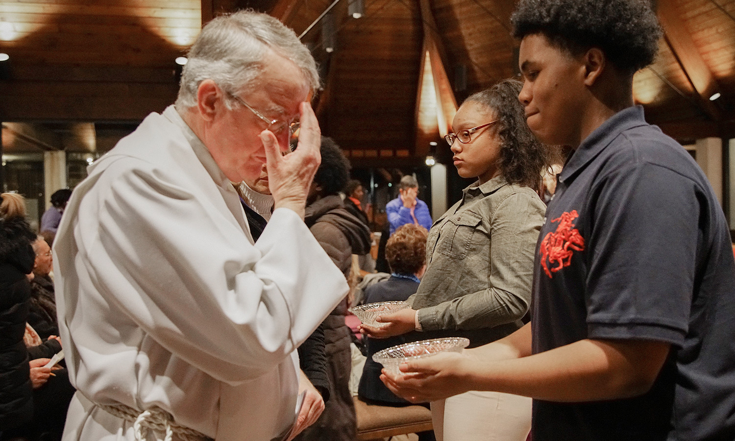 Father Jerry Deponai, pastor of St. Anthony’s, blesses himself with the Lourdes holy water.