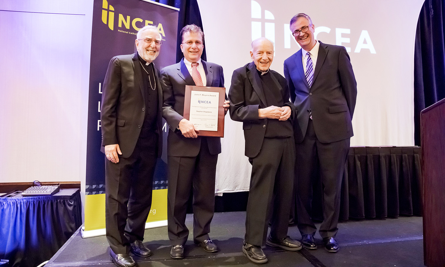 NCEA Board Chair Bishop Gerald Kicanas, far left; honoree Steven Virgadamo, associate superintendent for leadership formation for the archdiocese; Msgr. John F. Meyers, the namesake of Virgadamo’s award; and NCEA President/CEO Dr. Thomas Burnford smile broadly after Virgadamo was recognized at an awards banquet April 2 at the National Catholic Educational Convention & Expo in Cincinnati.