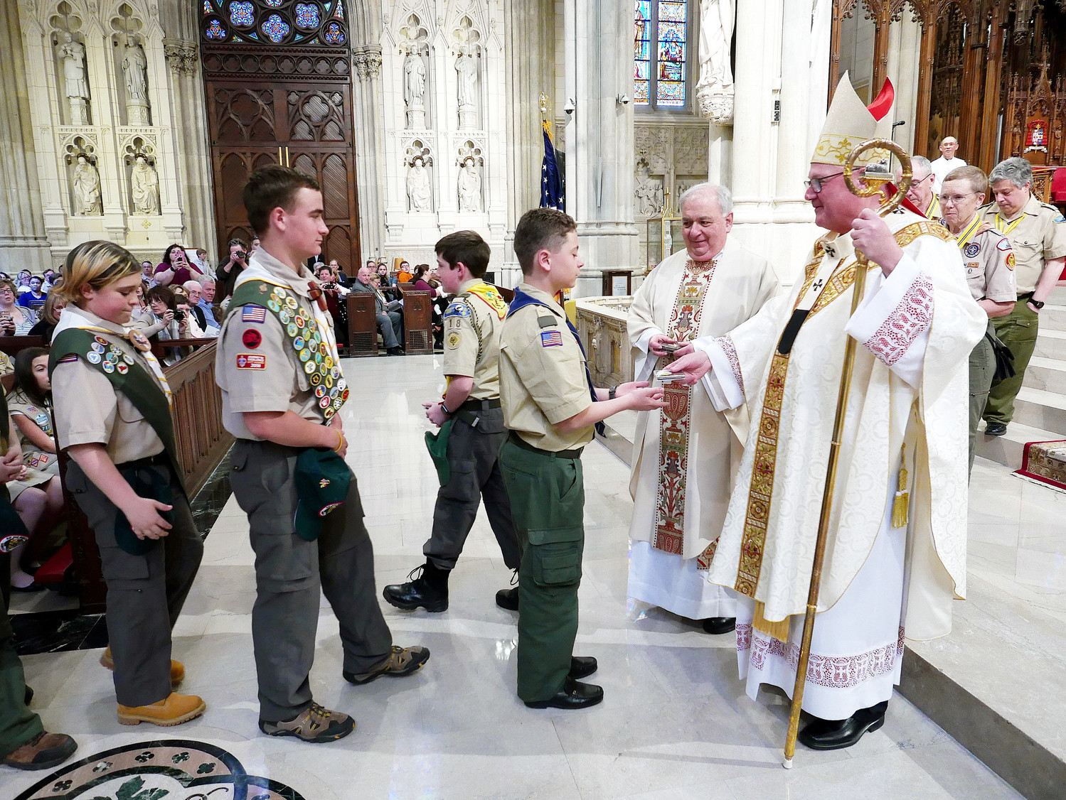 Cardinal Dolan presents medals to the scouts with assistance from Msgr. Anthony Marchitelli, scouting chaplain.