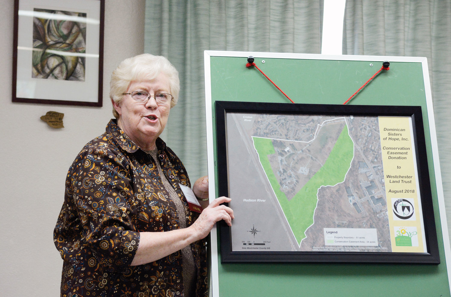 Sister Lorelle Elcock, O.P., prioress of the Dominican Sisters of Hope, discusses the conservation easement, using a map of the property, at the press conference.