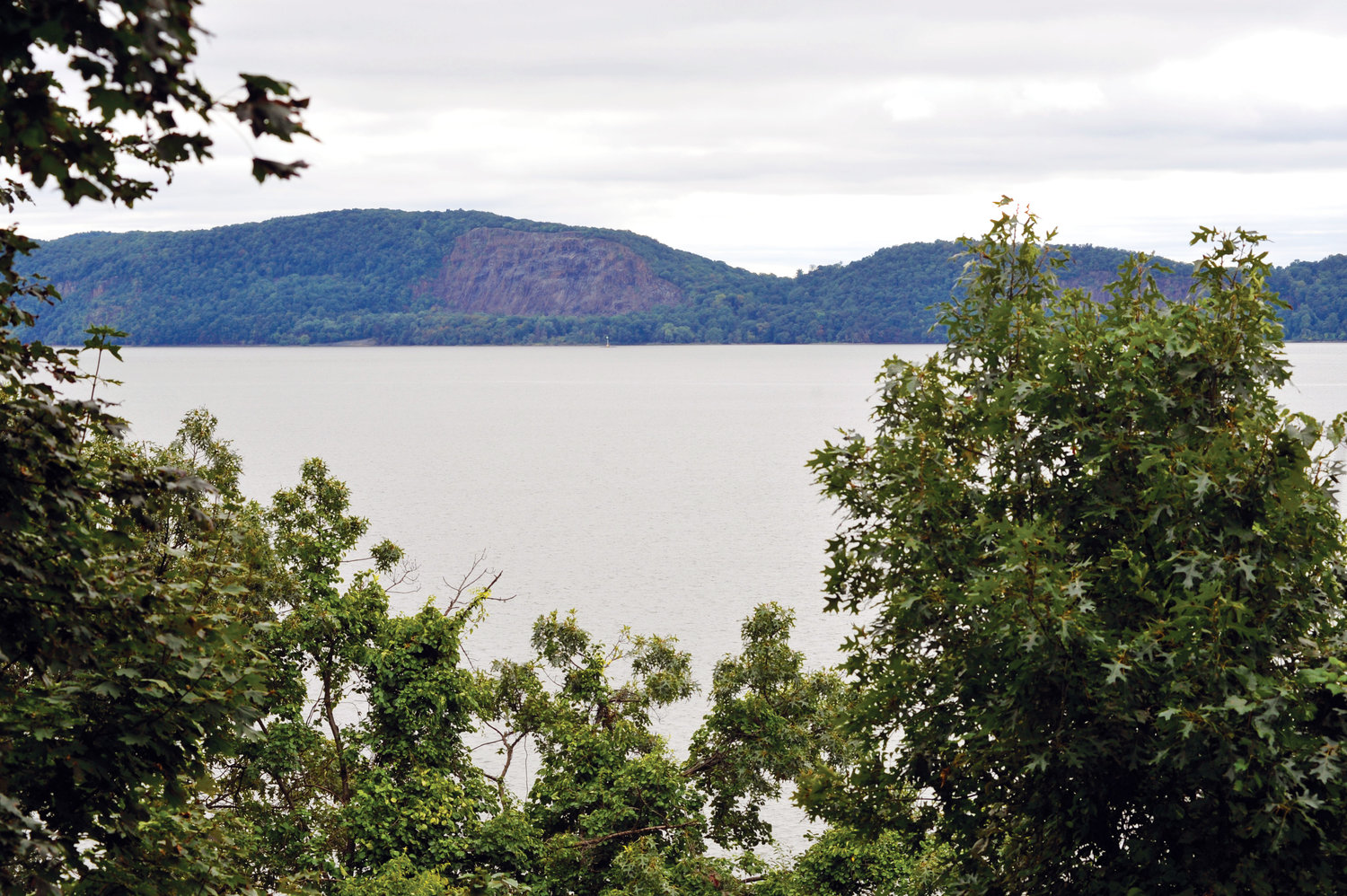 A view beyond the trees at Mariandale shows the Hudson River and the landscape of Rockland County.