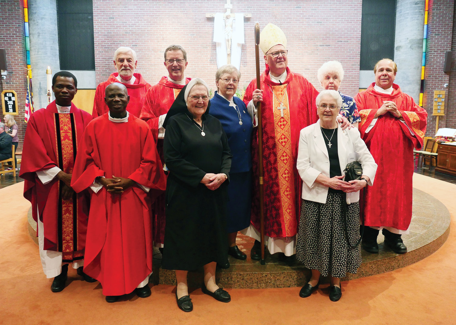 Cardinal Dolan joins, from left, Father John Kwaku Sah, parochial vicar; Father Andrew Amankwaa; Deacon Anthony Ferraiuolo; Father Rees Doughty, pastor; Sister Mary McCaffrey, O.S.F.; Sister Helen Hofmann, O.S.F.; Sister Barbara Ann Sansone, O.S.F.; Sister Rose Jerome Kenlon, O.S.F.; and Deacon Lenny Farmer. The Orange County parish is awaiting approval for a name change to St. Marianne Cope.