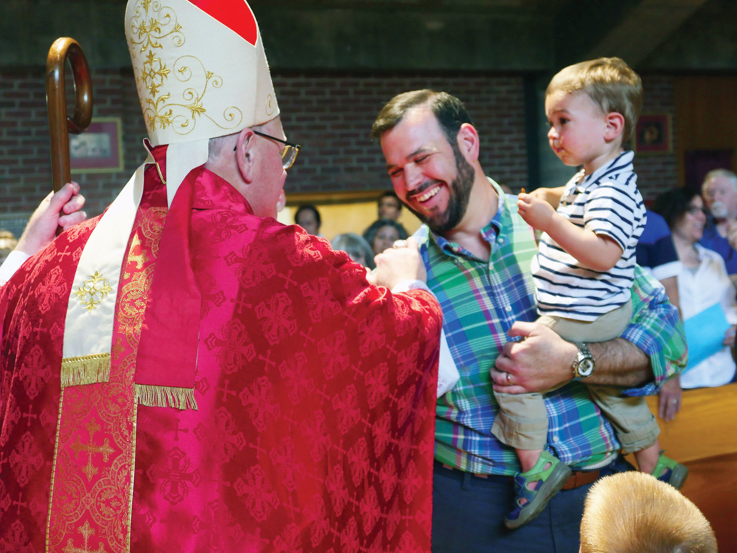 Cardinal Dolan greets parishioner Jim Kreagan and his son, Charlie.