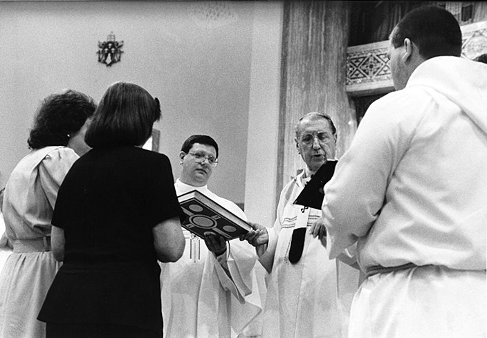 PRIESTLY SERVICE—Cardinal John O’Connor, right, holds Book of the Gospels with Father Gerdardo Colacicco, who he installed as pastor of Sacred Heart parish in Newburgh June 29, 1996.