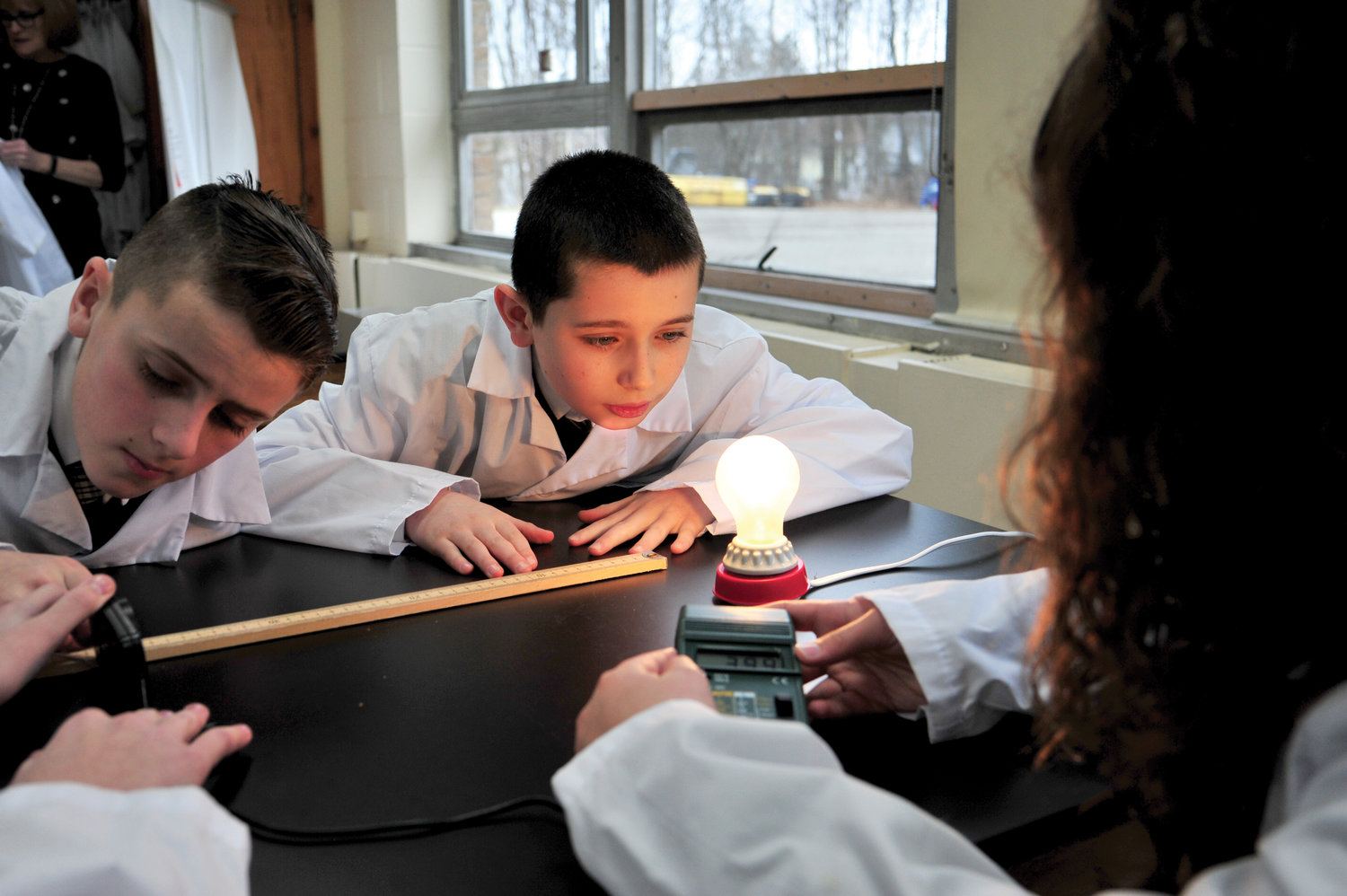 Sixth-grader John Cassidy, center, participates in an experiment involving electricity with classmates at St. Denis-St. Columba School in Hopewell Junction Jan. 10.