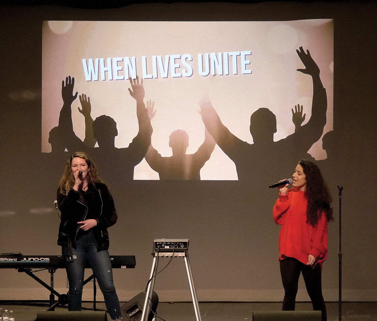 Brianne Nealon, left, and Nicky Constabile, members of Array of Hope, sing during the retreat.