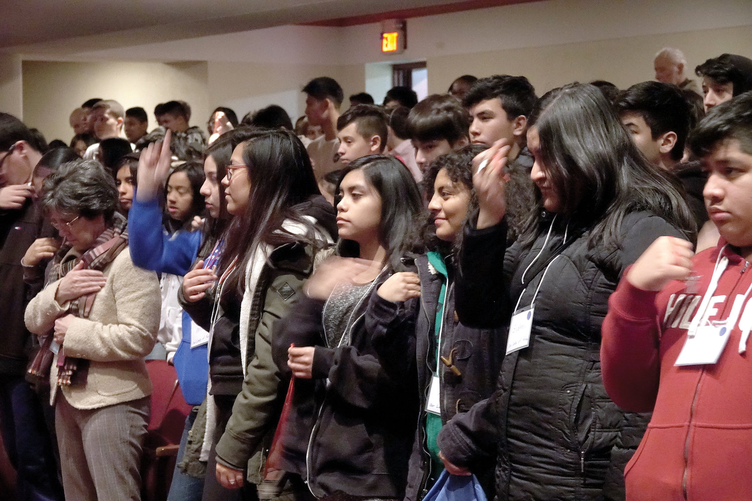 Students hold up their medals for a blessing by Auxiliary Bishop Gerald Walsh at a confirmation retreat at Archbishop Stepinac High School in White Plains Feb. 23.
