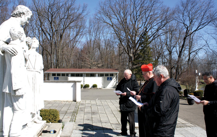 SHRINE PRAYERS—Cardinal Dolan prays at a statue of St. John Bosco at the Shrine of Mary Help of Christians in Stony Point March 21. Joining the cardinal were Father Stephen Ryan, S.D.B., left, and Father James McKenna, S.D.B.; in the back was Father Michael Pace, S.D.B. The shrine was one of three in the archdiocese the cardinal visited last weekend to offer prayers for healing and protection in the coronavirus pandemic.