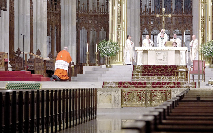 Auxiliary Bishop Edmund J. Whalen elevates the Eucharist at Mass on St. Patrick’s Day. Daily and Sunday Masses at the cathedral are available via livestreaming at saintpatrickscathedral.org.