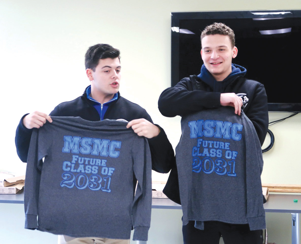 STRONG BOND—Joseph Galasso, left, vice president of the Mount St. Mary College Student Government Association, and Eddie Arnold, president of the SGA, presented the fifth graders of Bishop Dunn Memorial School with SGA T-shirts in February at the Newburgh grade school.