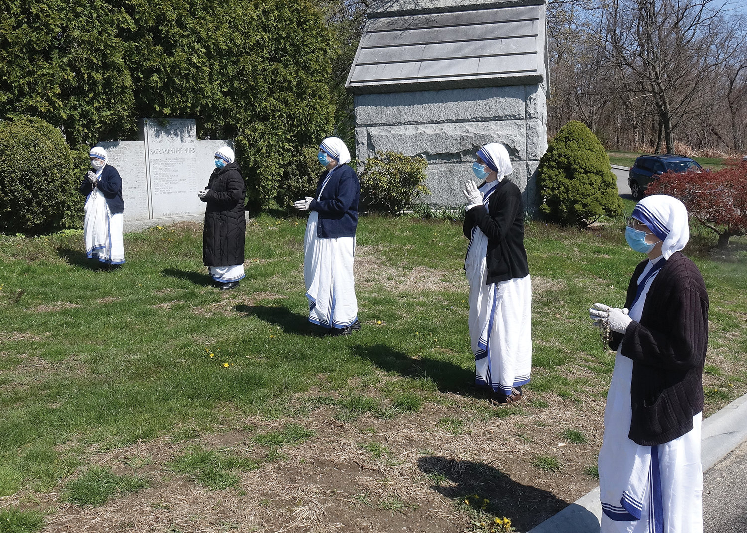 Missionaries of Charity sisters maintain a prayerful posture at a safe distance.