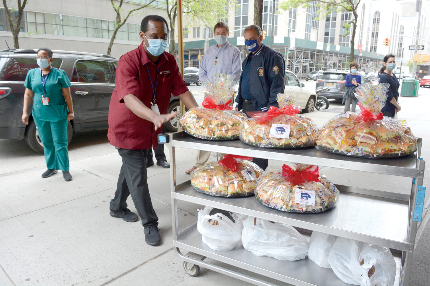 A luncheon of 250 sandwiches is wheeled into the home. Carmine Musumeci of Marquette Council 157 in Manhattan and a Supreme director with the Knights of Columbus watches on right.