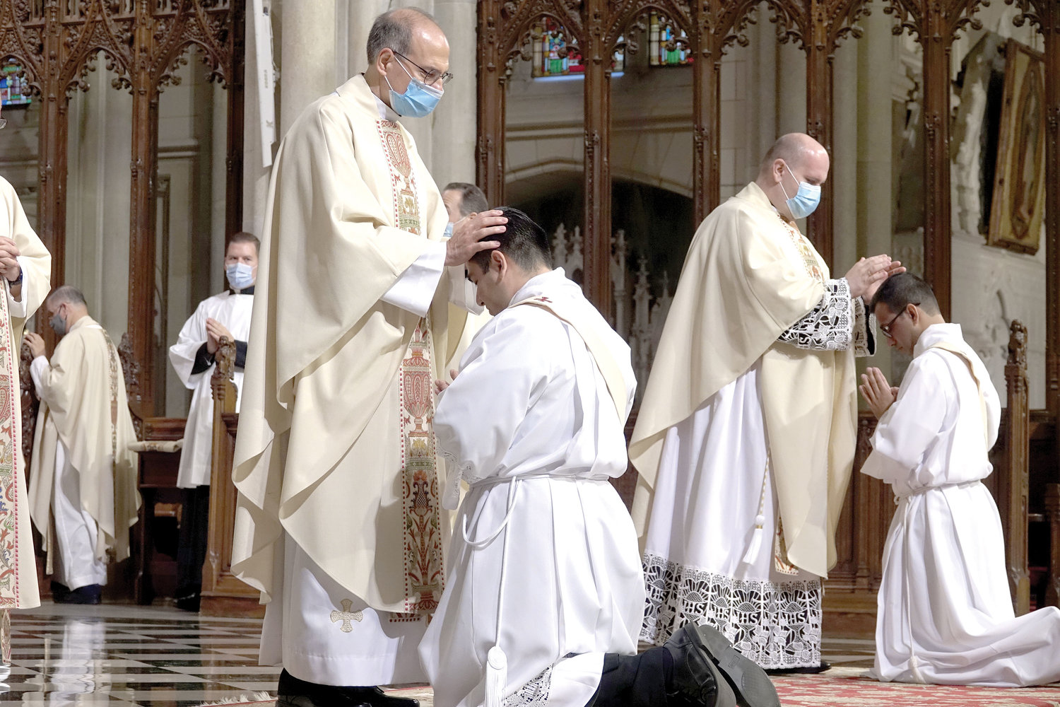 Priests lay hands on priesthood candidates Luis Silva Cervantes and Roland Pereira, M.Id., during the June 26 Ordination Mass at St. Patrick’s Cathedral.