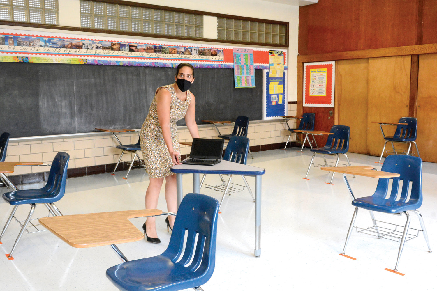 Amy Rodriguez, principal of Immaculate Conception School on East Gun Hill Road in the Bronx, gives a tour of the school showing coronavirus protocols in place July 22. Four pieces of tape strategically placed on the floor below the base of each leg of the desk chairs mark the spots to maintain a safe social distance.