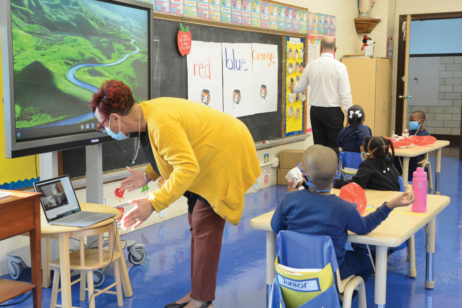 Kindergarten teacher Estoria Wills teaches students on Zoom Sept. 22. In the background assisting students is principal Rich Helmrich.