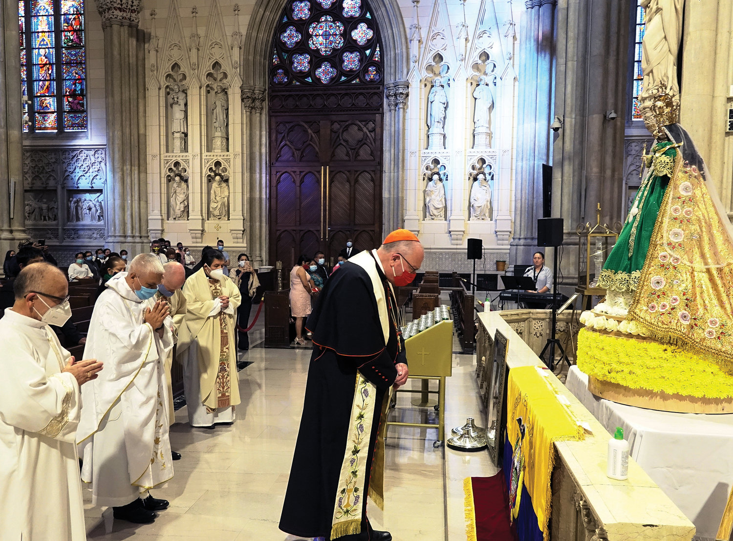 El cardenal Dolan y otros miembros del clero oran en silencio ante una estatua de Nuestra Señora de El Cisne en la Catedral de San Patricio del 27 de septiembre durante la misa anual celebrada en honor a la patrona de Ecuador.