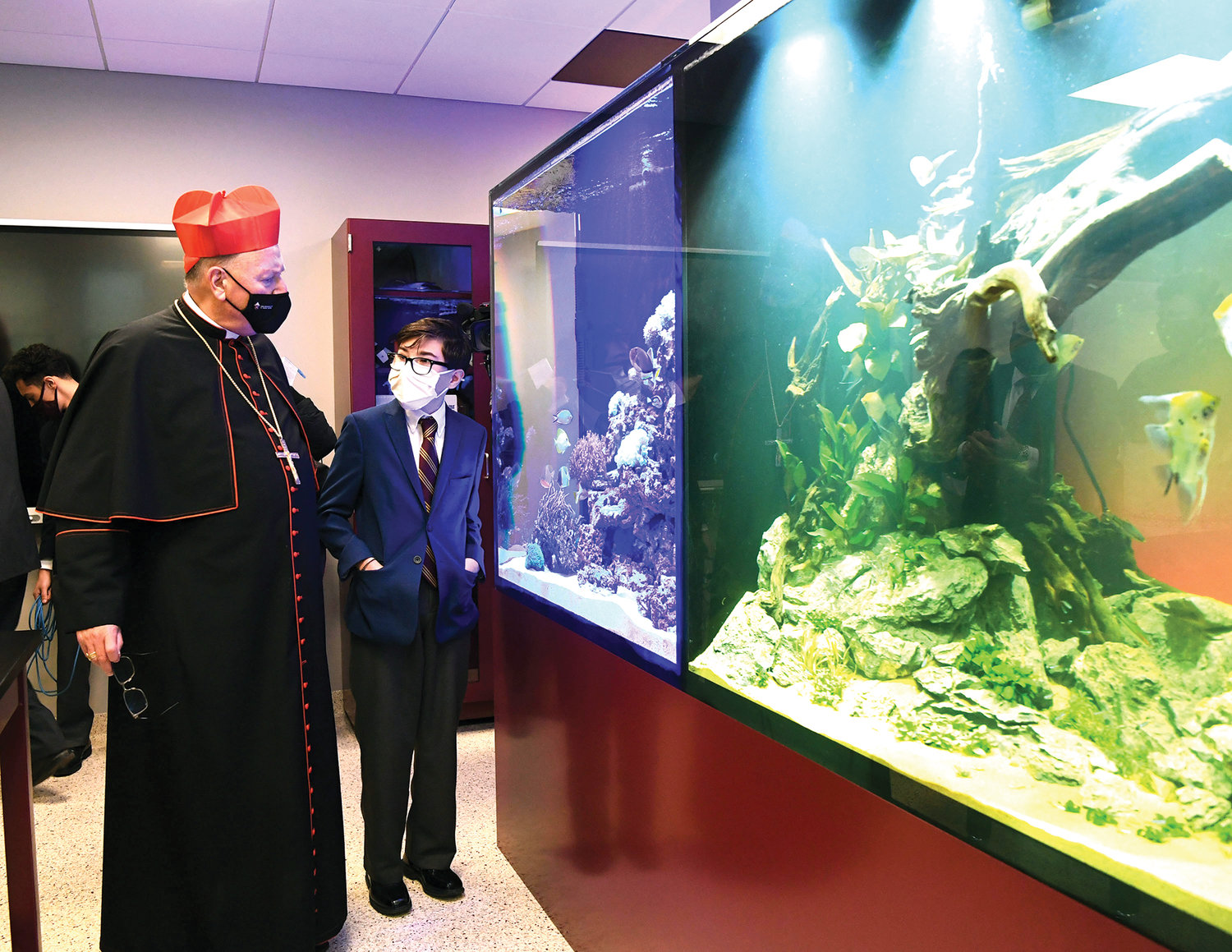 Cardinal Dolan looks at two new tanks: a tropical saltwater coral ecosystem and a freshwater environment in the new biology laboratory.