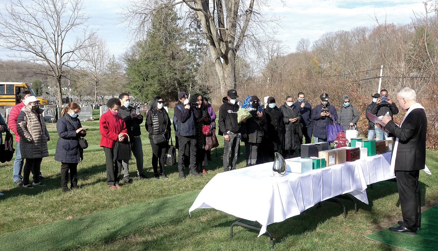 Father Daniel Kearney, pastor of Ascension parish in Manhattan, leads family and friends in prayer before the cremated remains of 18 people with parish ties were interred in the St. Joseph of Arimathea section of Gate of Heaven Cemetery in Hawthorne Nov. 21.