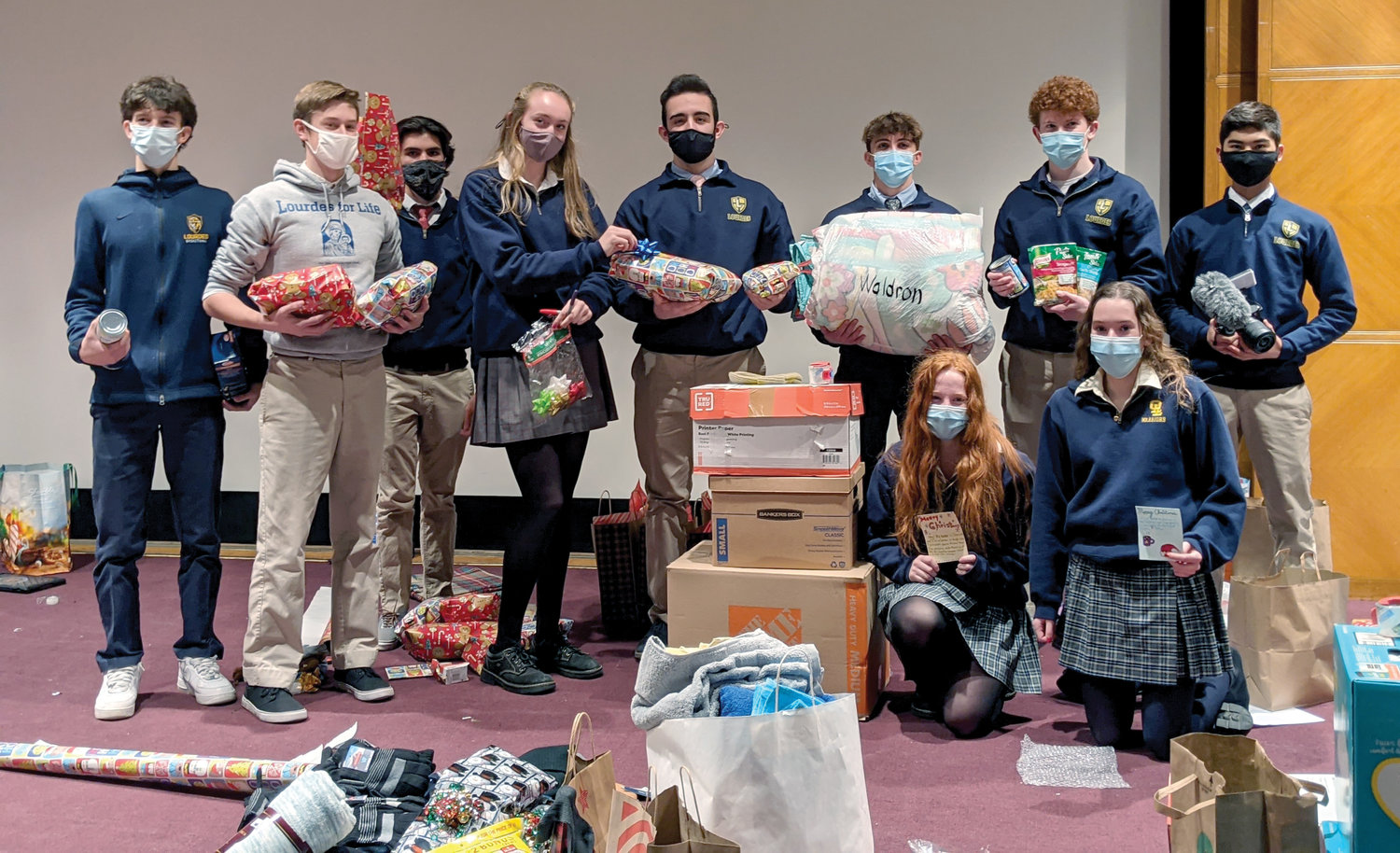 Seniors in principal Catherine Merryman’s theology class at Our Lady of Lourdes High School in Poughkeepsie hold hats, gloves and blankets they collected for Newburgh Ministry.