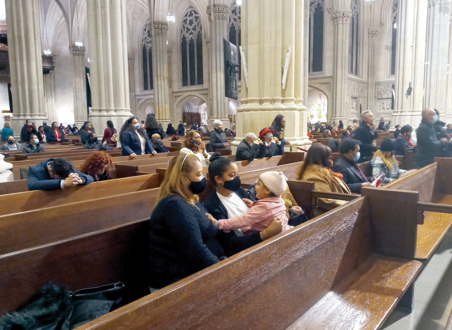 THREE GENERATIONS—Consuelo Rosa, foreground, and her daughter Yanely Polanco Rosa were present at the annual Our Lady of Altagracia Mass Jan. 17 at St. Patrick’s Cathedral. On Ms. Polanco Rosa’s lap is her daughter Emma, 3. The family members were part of an estimated congregation of 300. The principal celebrant and homilist was retired Auxiliary Bishop Octavio Cisneros of the Diocese of Brooklyn. Our Lady of Altagracia is the patroness of the Dominican Republic.