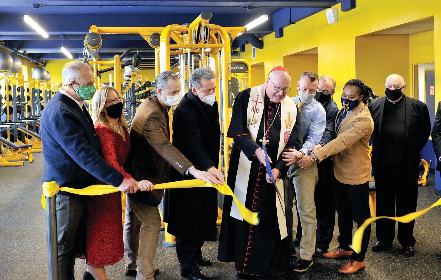 Cardinal Dolan cuts ribbon during the dedication and blessing of the new health and wellness center at Our Lady of Lourdes High School in Poughkeepsie Feb. 10. Standing, from left, are Tom Kelly, executive chairman, board of trustees; Catherine Merryman, principal; Genaro Argenio, former executive chairman, board of trustees; Hal Pontez, benefactor; Bill Kyle, athletic director; Mike Krieger, assistant principal for academics; Miles Hansen, athletic trainer; and Msgr. Joseph LaMorte, vicar general and moderator of the curia for the archdiocese.