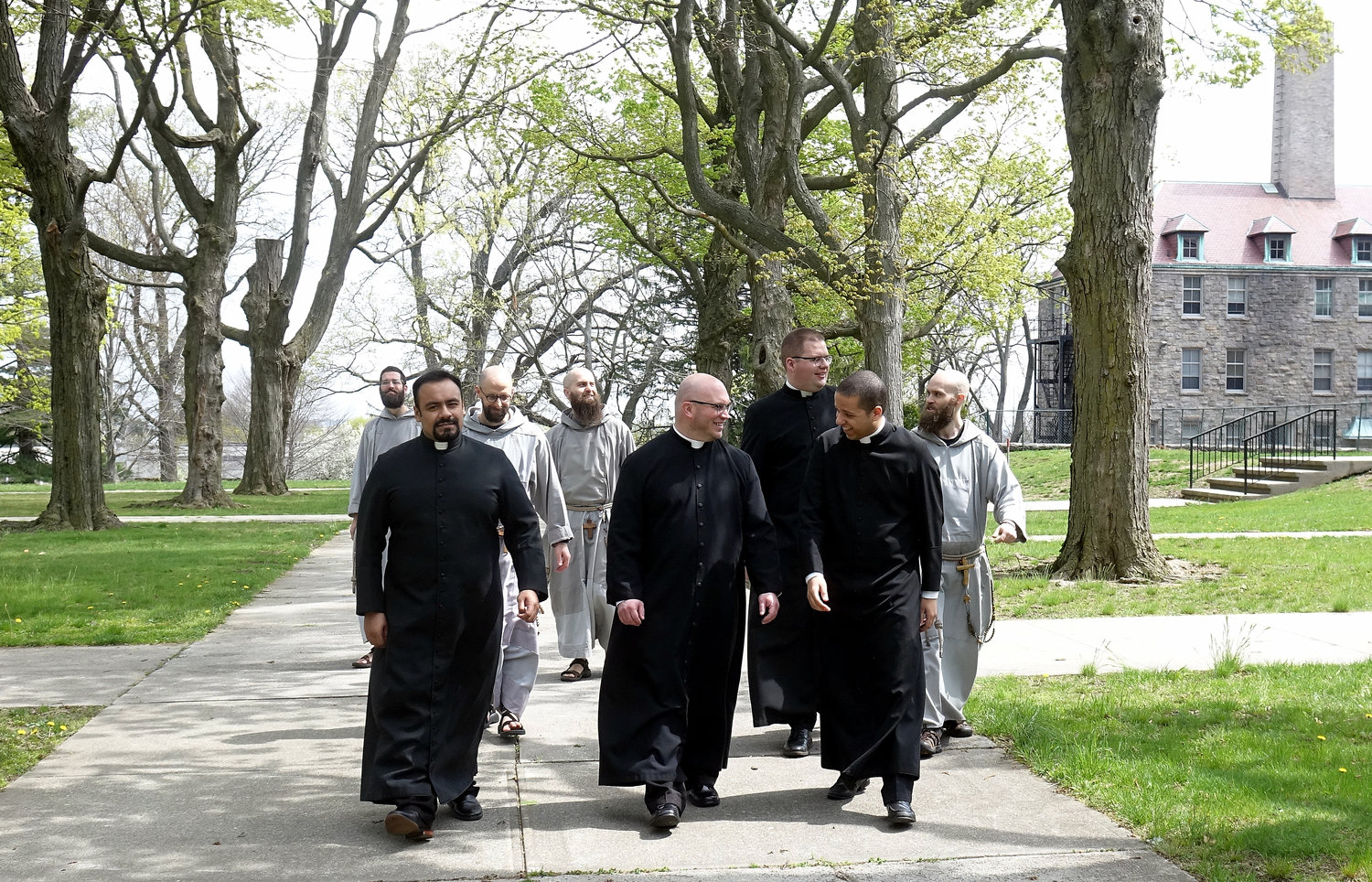 SPRING STROLL—The eight members of the Class of 2021 of St. Joseph’s Seminary enjoy a walk on the tree-lined Dunwoodie campus last month. In the front row, from left, are Father Kevin Panameño, Father Robert Carolan and Father Steven N. Gonzalez. Cardinal Dolan will ordain all eight to the priesthood at a Mass in St. Patrick’s Cathedral May 29.