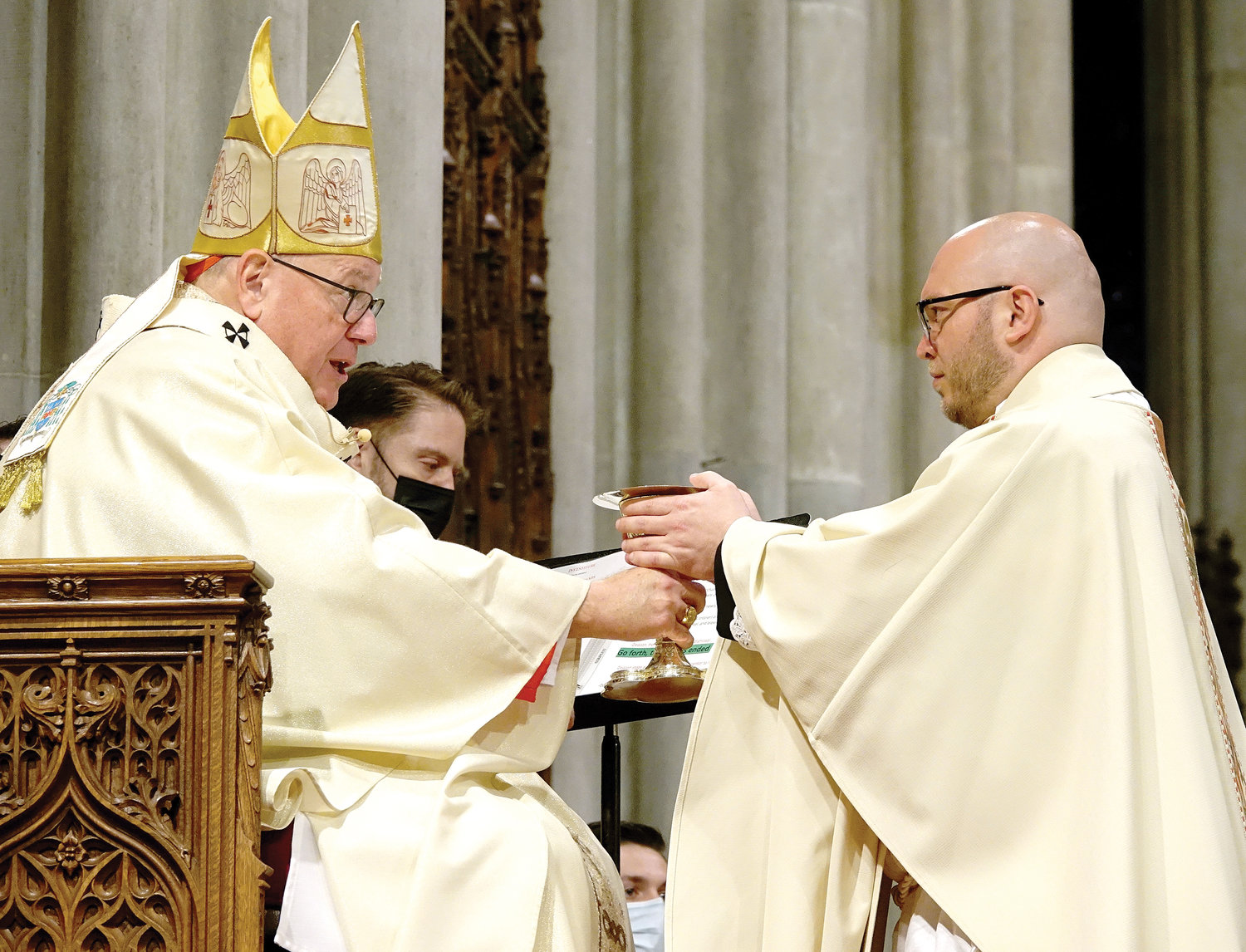 Newly ordained Father Robert Carolan accepts the paten and chalice from Cardinal Dolan during the Mass of Ordination May 29 at St. Patrick’s Cathedral.
