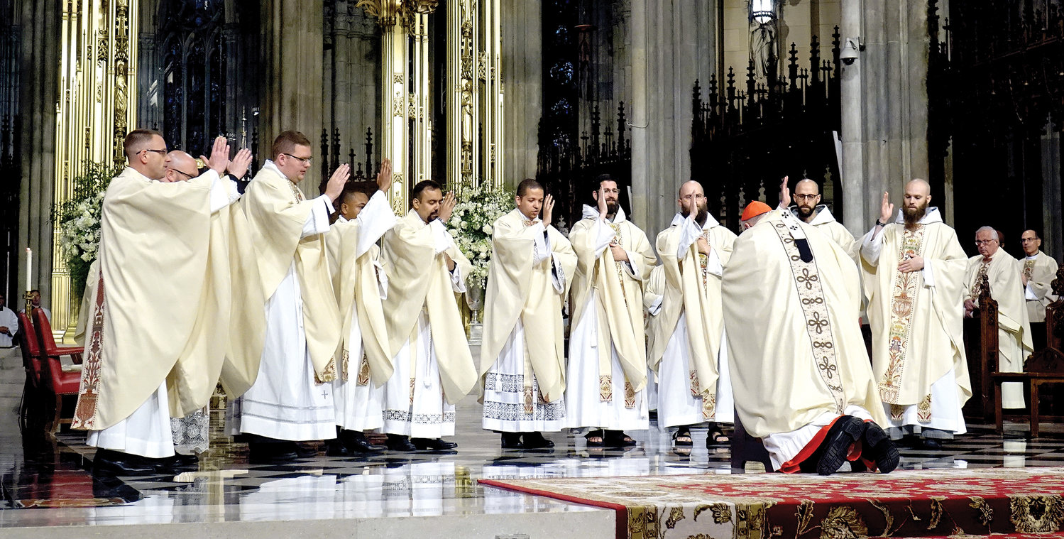 The 10 new priests extend their first blessings to Cardinal Dolan who had ordained them a short time earlier.