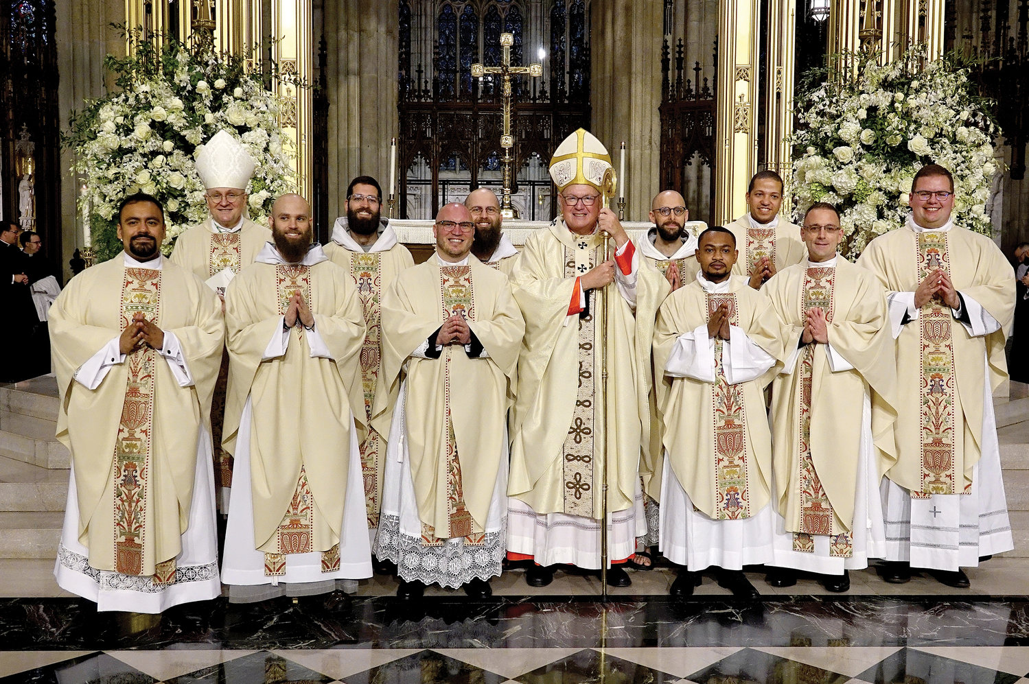 Joining Cardinal Dolan after the Mass of Ordination were the 10 men he ordained. First row, from left, were Father Kevin Panemeño, Father Elijah Marie Perri, C.F.R., Father Robert Carolan, Cardinal Dolan, Father Wesbee Victor, Father Carmine Caruso and Father Matthew Breslin. Back row, from left, were Auxiliary Bishop James Massa of Brooklyn, the rector of St. Joseph’s Seminary, Dunwoodie, Father Joseph Michael Fino, C.F.R., Father Ignatius Pio Mariae Doherty, C.F.R., Father Frantisek Marie Chloupek, C.F.R., and Father Steven Gonzalez.