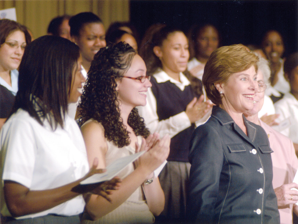 First Lady Laura Bush visited Aquinas on Sept. 11, 2002, the first anniversary of 9/11. Standing next to the first lady is Charlene Cruz, a graduate of Aquinas who invited Mrs. Bush to the school the previous spring when she was student council president.