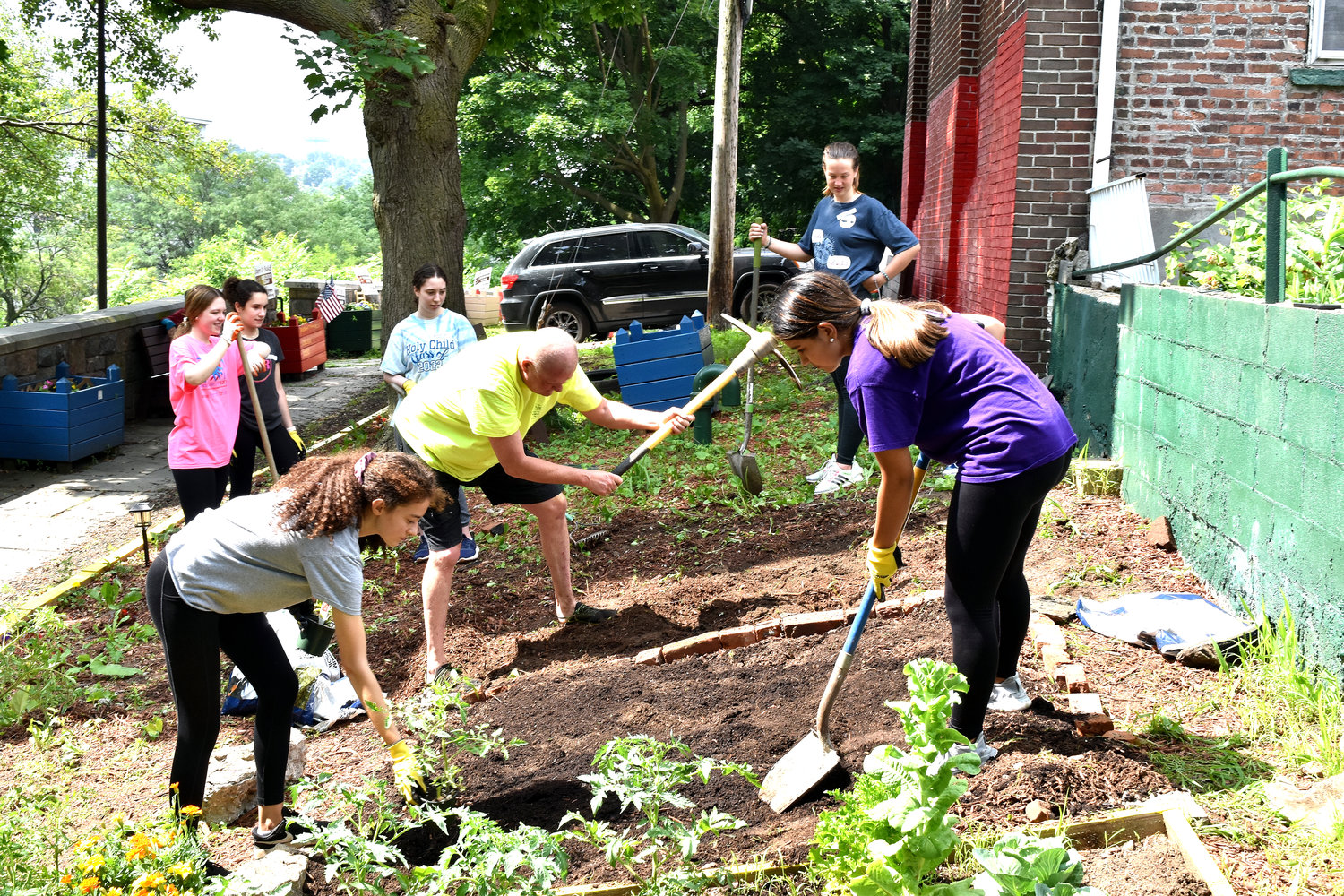 Students, coordinators and other volunteers work on the garden.