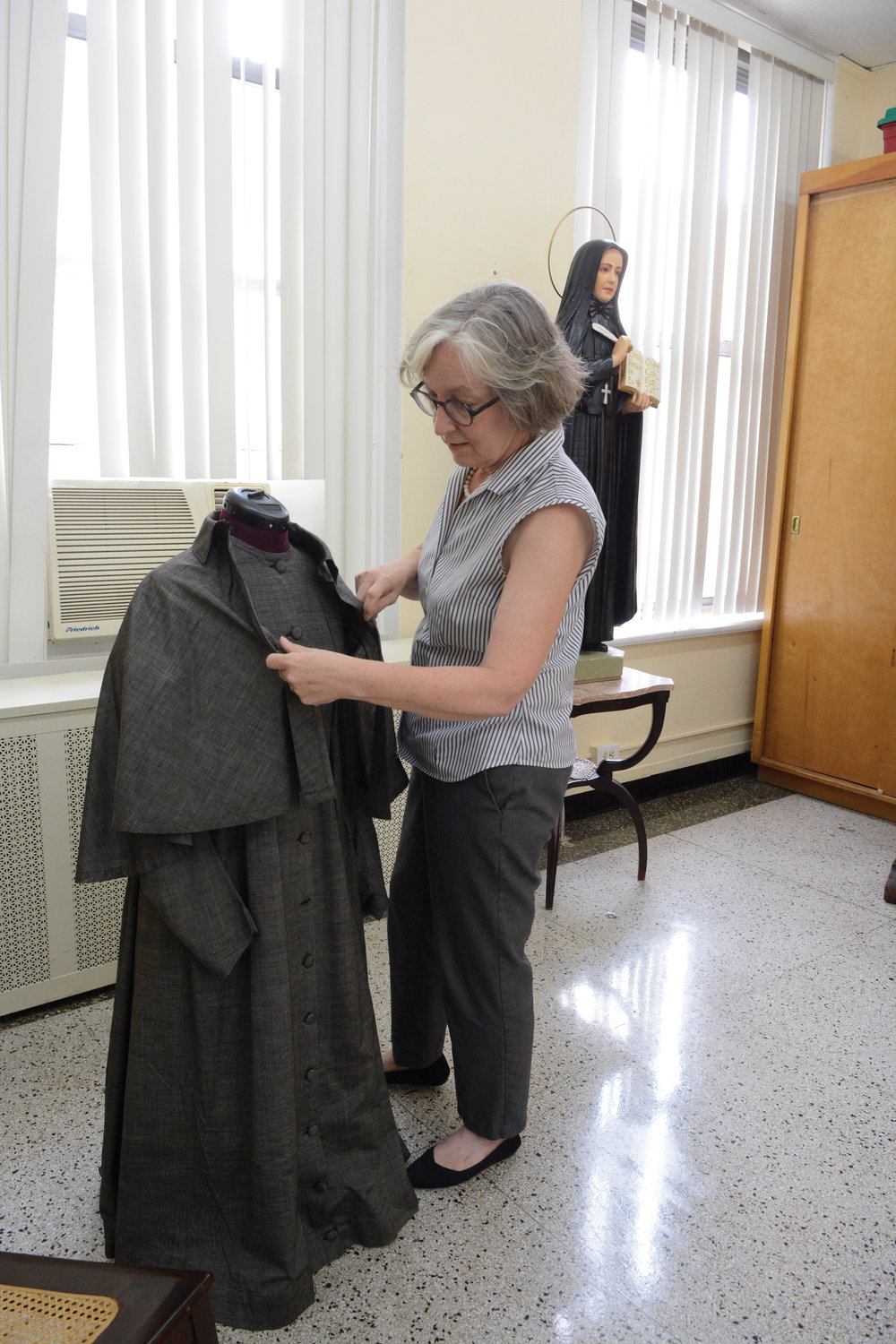Julia Attaway, directora ejecutiva del santuario, ajusta atuendo de época de Madre Cabrini el 8 de julio.