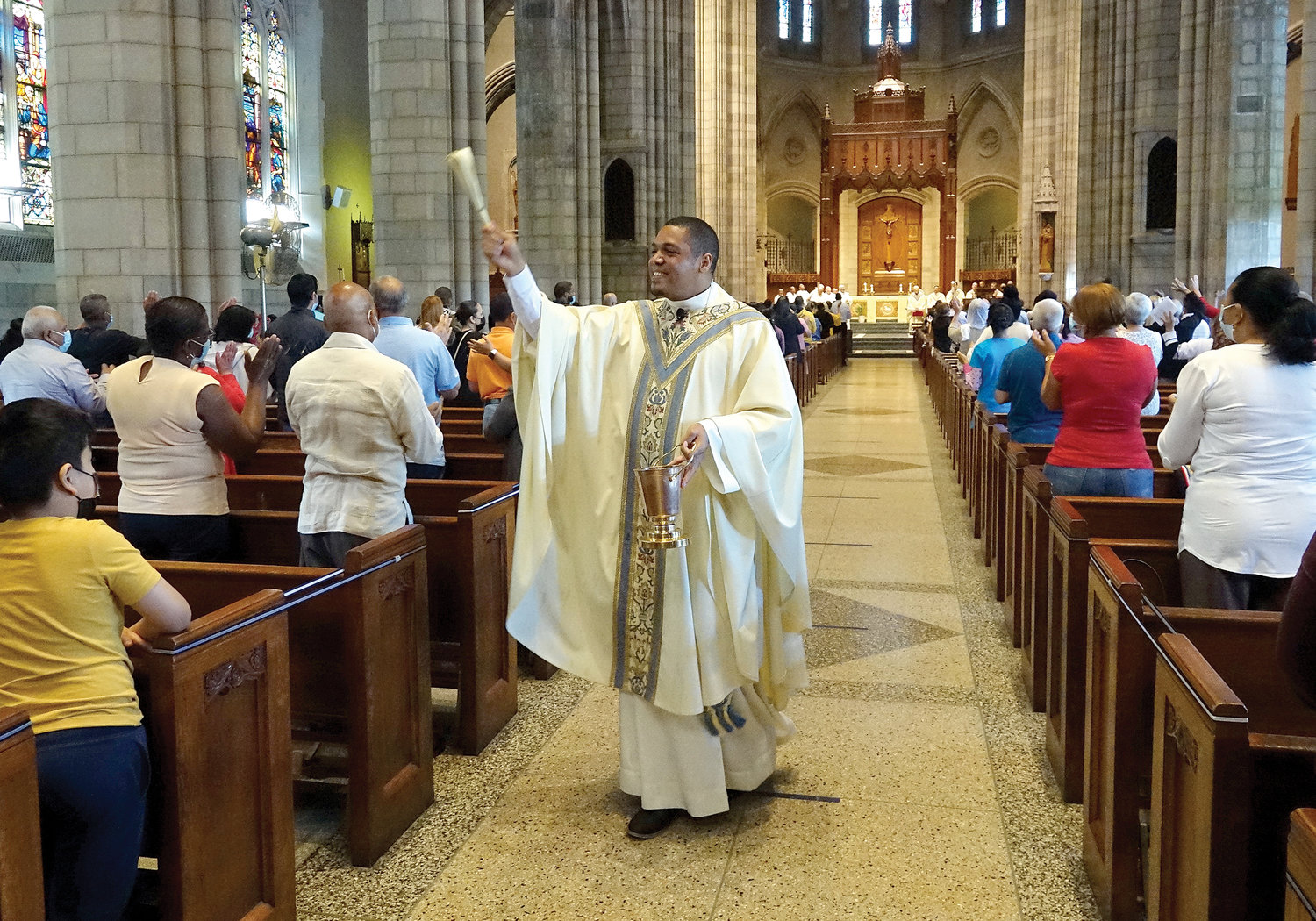 El padre Elizandro Contreras, O.S.A., extiende sus bendiciones a los feligreses de St. Nicholas of Tolentine en el Bronx el 4 de julio durante una misa de las gracias que él ofreció en la iglesia.