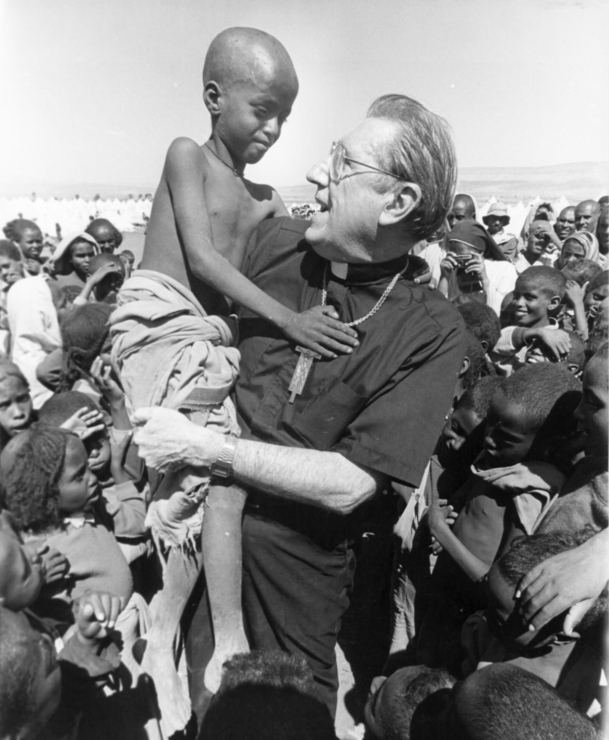 Cardinal John O’Connor, then-archbishop of New York, lifts a boy during a pastoral visit to Ethiopia in February 1985. The cardinal made the trip in his role as president of the Catholic Near East Welfare Association. Gerald M. Costello covered the journey in his role as editor in chief of Catholic New York.