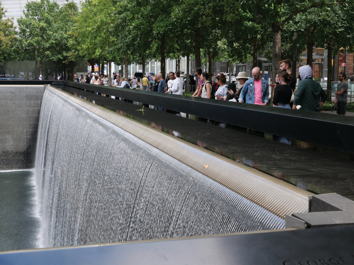 People gather around a reflecting pool of cascading water at the 9/11 Memorial in lower Manhattan Sept. 3.