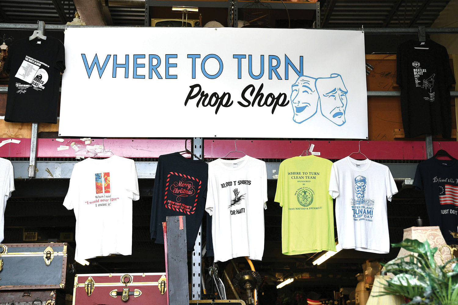 A sign and display of T-shirts welcome visitors to the Prop Shop, where numerous items are available for loan to local community theater groups and school productions. McKeon belongs to St. Clare parish on Staten Island.