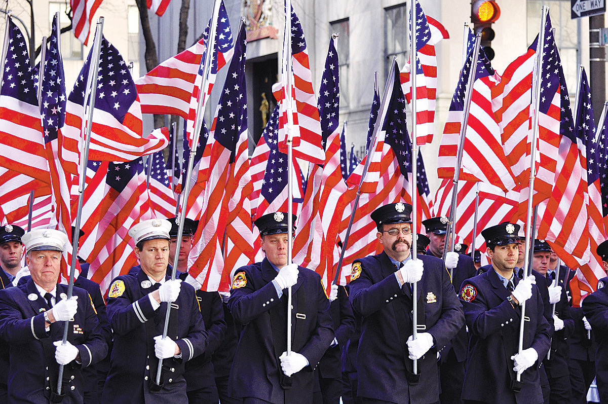 American flags are held aloft at the New York City St. Patrick’s Day Parade in 2011 representing the 343 firefighters killed in the 9/11 attacks on the World Trade Center.